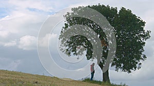 Guy peeing in park, young man urinating on tree, human influence on ecology