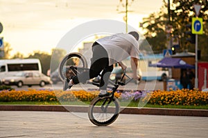 The guy performs a stunt on BMX, standing on the front wheel