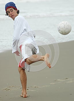 Guy playing beach soccer