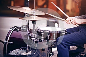 Guy playing rhythm on a red drum set with drumsticks photo