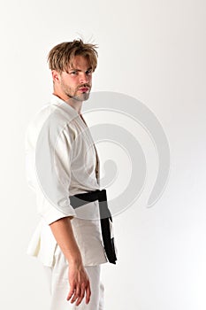 Guy poses in white kimono with black belt. Healthy lifestyle