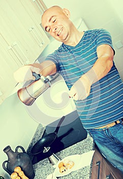 Guy pours coffee into cup of coffee pot photo