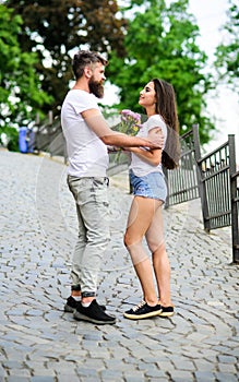 Guy prepared surprise bouquet for girlfriend. Romantic date walk. Gentlemans manners. Man gives flower bouquet to girl