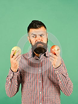 Guy presents homegrown harvest. Farmer with indecisive face