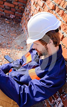 Guy protective helmet bearded handsome builder. Take minute to relax. Man take break working day at construction site