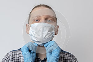 Guy puts on respiratory mask. Attractive man puts on face mask and looks at camera. Cold, flu, virus, tonsillitis, acute