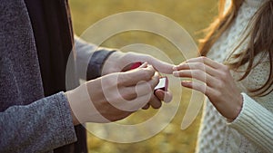 Guy putting beautiful diamond ring on finger of his bride, serious relationship