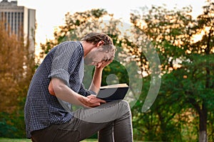 Guy reading book in park