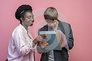 Guy reading notebook and woman watching approvingly