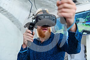 A guy with a red beard plays virtual reality games