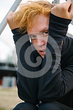 A guy with red hair looks seductively into the camera