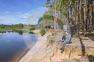 Guy relaxes in nature near the river