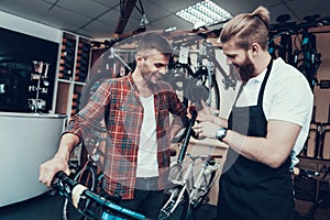 Guy and Repairman Fixes Bicycle in Sport Store