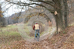 Guy rides a bicycle in the autumn at high speed in nature