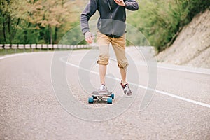 Guy riding on longboard asphalt road.
