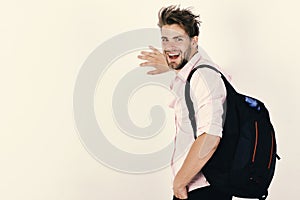 Guy with rucksack and happy face. Young man backpacker walking in studio