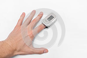 The guy`s hand measures saturation with a modern medical device pulse oximeter on a white background