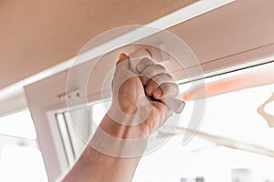 The guy`s hand opens a plastic double window for the handle pvc double glazing