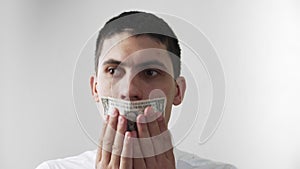 The guy`s mouth sealed with dollar bill. Panic. Can`t speak. The theme of bribery and corruption. On a white background