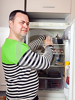 Guy searching for something in refrigerator