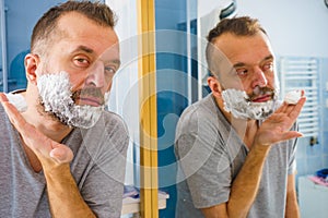 Guy shaving his beard in bathroom