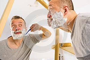 Guy shaving his beard in bathroom