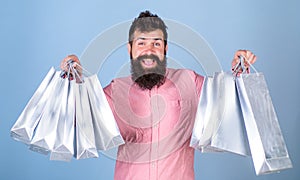 Guy shopping on sales season with discounts. Sale and discount concept. Hipster on happy face is shopping addicted or