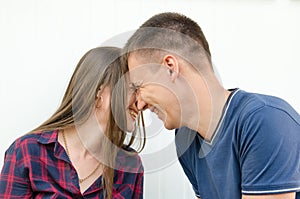 Guy with short haircut and girl with long hair and freckles smiling touch their heads