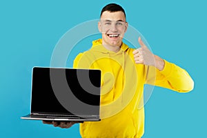 Guy Showing Laptop Blank Screen Gesturing Thumbs Up, Blue Background