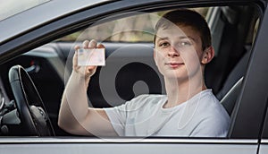 Guy shows the driver license out of the car window