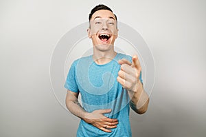 Guy shows hand, laugh and mock at someone on a light background