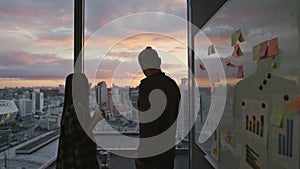 Guy silhouette thinking evening office closeup. Business couple drinking coffee