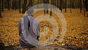 Guy sitting in park inspired by beautiful nature and thinking about past life photo