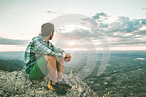 Guy sitting on a rock on the mountain watching a sunset. Social network style photo