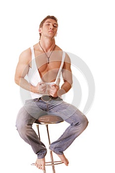 Guy in sleeveless shirt and jeans sitting on chair
