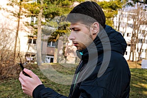 Guy with a smart phone using in the park