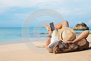 Guy with smartphone lying on the beach