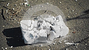 A guy smashes a white piece of rock with a baseball bat. Close up