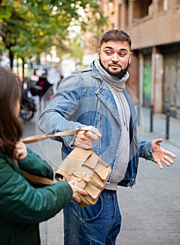 Guy snatching handbag of woman on street