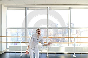 Guy spotting in white suit and raving at studio.