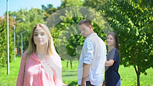 Guy staring at passing blonde walking along park with his girlfriend, lovelace