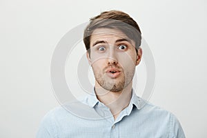 Guy is startled and stunned of seeing someone very ugly. Portrait of shocked and confused handsome man tilting head