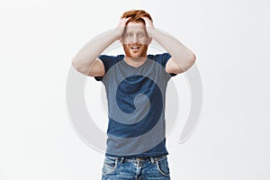 Guy starts panicking lacking time to prepare papers. Nervous and anxious attractive ginger man with beard, touching hair