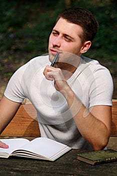 Guy and student takes notes in notebook, learning and writes thoughts, writes the book, he is preparing his final exams.