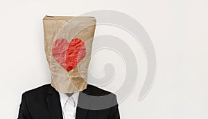 A guy in suit wearing brown paper bag with heath shape