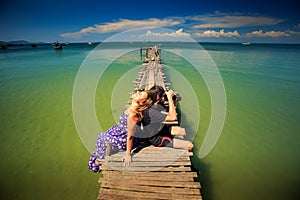 Guy Takes Photo Girl Sits on Pier against Ocean