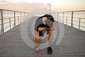 guy takes rest bent over in exhaustion after jog outdoor