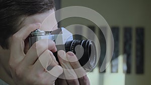 A guy taking pictures with an analog camera in an interior space. Amateur photographer or social media influencer