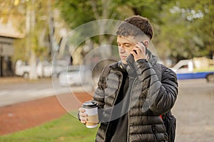 Guy talks on his mobile phone while walking through a public park
