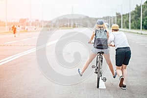 Guy teach his girl to ride a bike